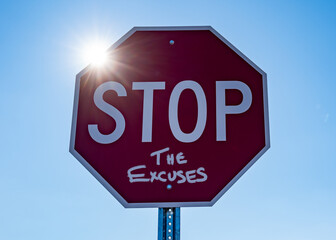stop sign against blue sky with sunshine reading stop the excuses