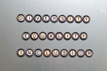 Diversity, Equality and inclusion, spelled out with vintage word magnets on a scratched silver...