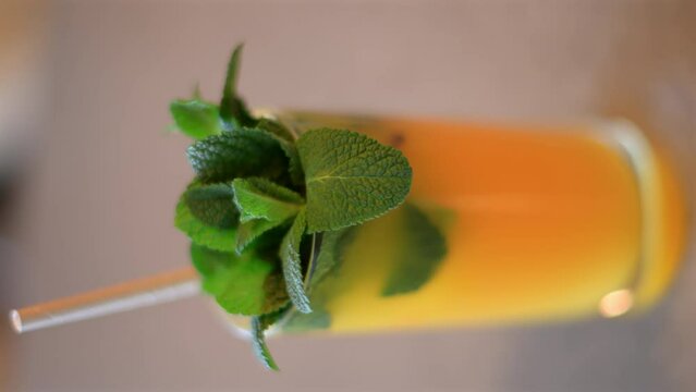 Fresh orange lemonade with mint leaves and paper straw