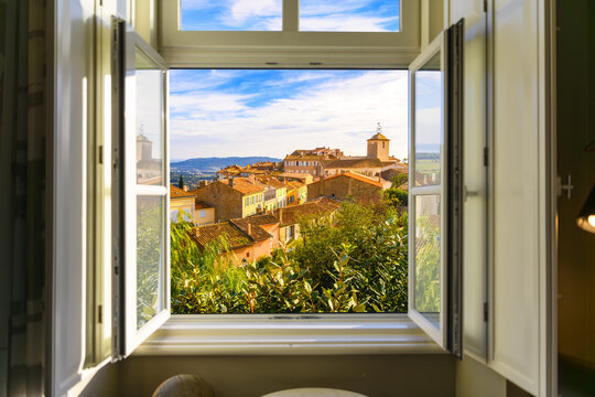 View through an open window of the townscape and skyline of Ramatuelle, France, a picturesque French Village in the Var Dept. of the Provence, Alpes Cote d'Azur region.