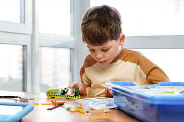 Smart boy assemble constructor. Smart child reading instruction constructor robotics kids...