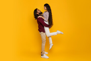 Loving handsome indian guy lifting up his beautiful girlfriend