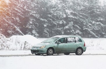 Car on a winter road. Dangerous driving conditions on the highway. Winter tires and undercarriage rust and corrosion concept. Slippery highway.