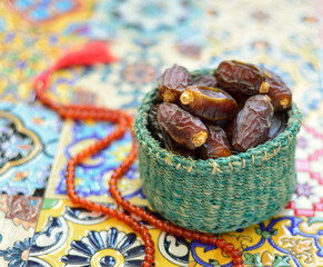 An Eco-friendly basket filled with sacred, organic date fruits. Ramadan photo with Arabian dates and Islamic rosary.