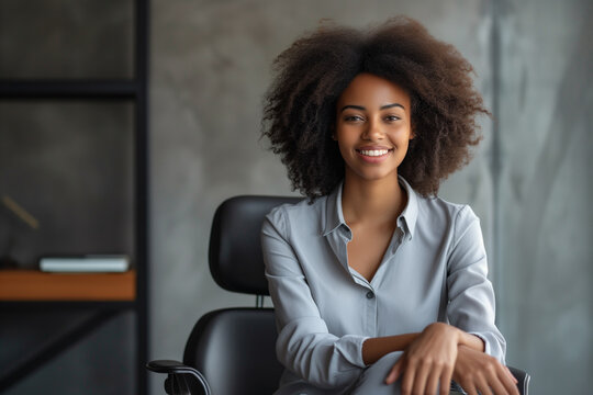 Smiling woman sitting position on a chair in minimalist interior background, Confident African woman with curly afro hair, Employee of the Month wallpaper concept, beautiful elegant woman portrait