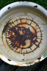 An old enameled basin with rust on the bottom, an old basin with water in the garden