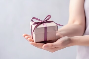 closeup view of a gentle hands presenting a neatly wrapped gift box, symbolizing thoughtfulness and care