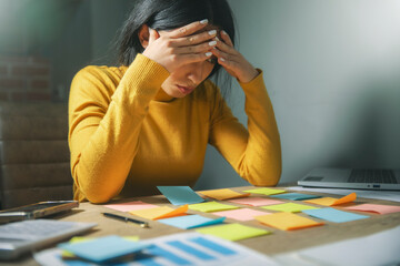 a woman sitting at a desk with sticky notes on the table