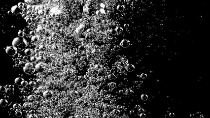 Soda water bubbles splashing underwater against black background. Soda liquid texture that fizzing and floating up to surface like a explosion in under water for refreshing carbonate drink concept.