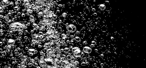 Soda water bubbles splashing underwater against black background. Soda liquid texture that fizzing and floating up to surface like a explosion in under water for refreshing carbonate drink concept. - obrazy, fototapety, plakaty