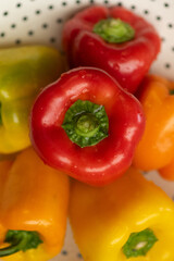 Close-up of red pepper from above with other peppers underneath.