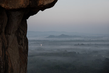 Morgenstimmung am Sigiriya Löwenfelsen in Sri Lanka mit Buddhastatue im Nebel