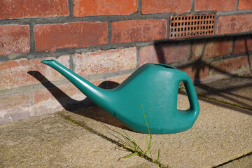 small watering can on garden patio. gardening equipment for watering plants and flowers 