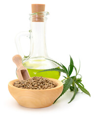 Hemp oil in glass bottle and fresh green hemp leaves.