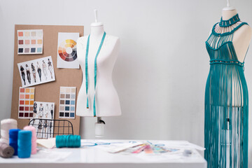 Trendy macrame dress of green threads in dummy in dressmaking shop sewing fashionable women clothes in contemporary atelier empty sewing studio interior
