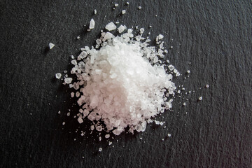 White salt cristals for food on the black background.