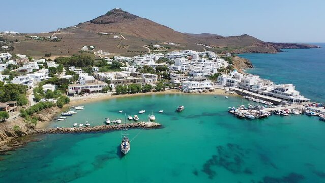 Aerial drone video of small coastal village and beach of Piso livadi in island of Paros, Cyclades, Greece