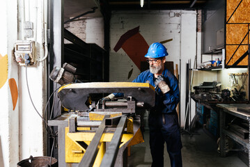 Factory worker using machine in workshop