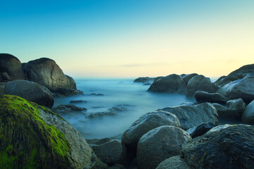 Fototapeta na wymiar Long exposure by the ocean on a rocky beach. Porto, Portugal