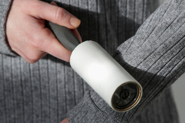 Hair remover roller. Woman using reusable clothes lint roller cleaner.