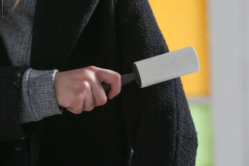 Hair remover roller. Woman using reusable clothes lint roller cleaner.