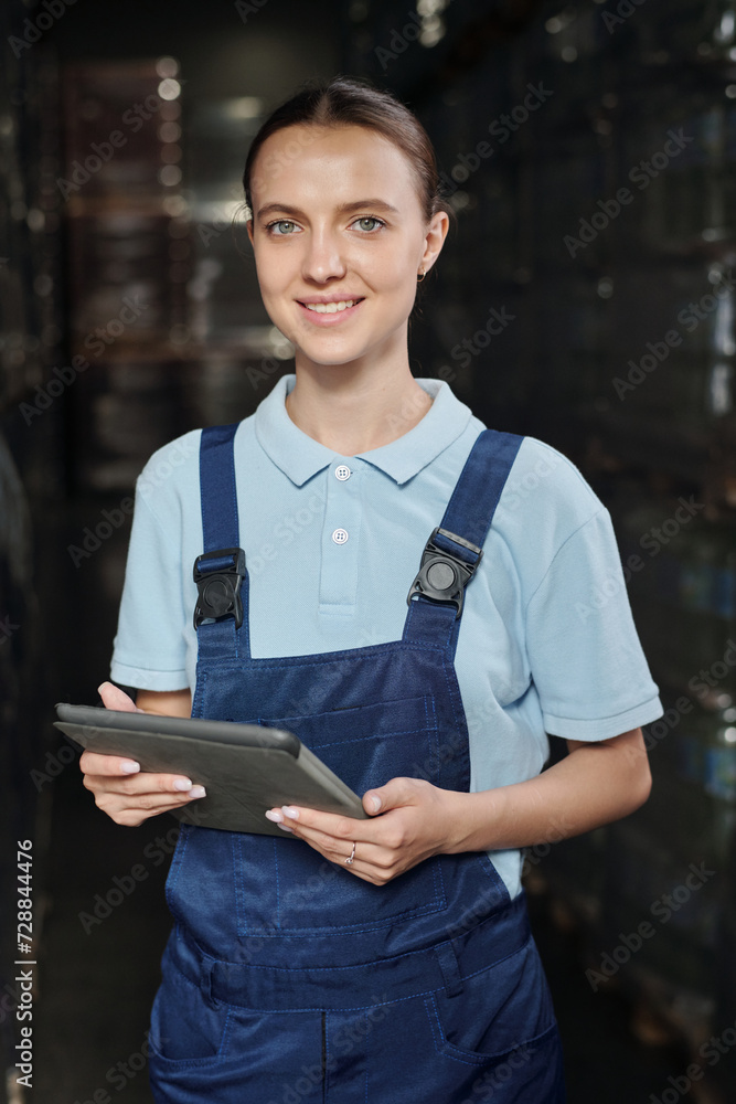 Aufkleber young successful female engineer or quality control inspector with tablet looking at camera while wo