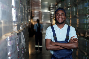 Young successful African American male engineer of warehouse in workwear looking at camera against...