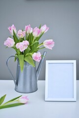 Pink tulips in a metal watering can and frame.  Congratulations.