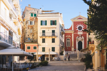 Fototapeta premium Corfu street view, Kerkyra old town beautiful cityscape, Ionian sea Islands, Greece, a summer sunny day, pedestrian streets with shops and cafes, architecture of historic center, travel to Greece