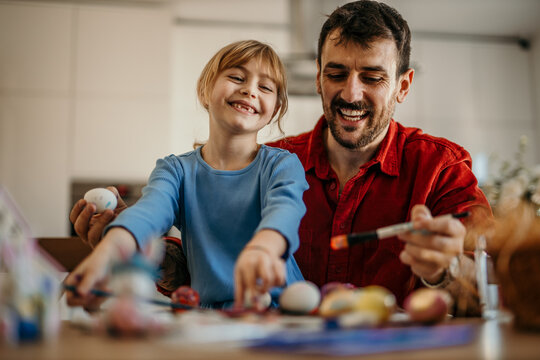 Dad and daughter engaging in Easter crafting in the dining room