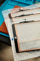 top view of new touchscreens for mobile phones in professional repair shop, small business