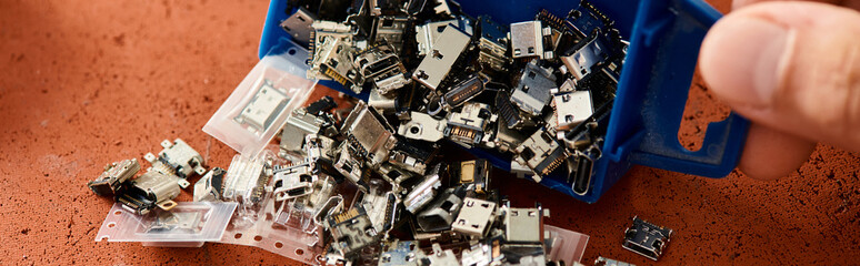 cropped view of skilled technician with plastic container of various spare parts in workshop, banner