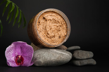 Coffee body scrub and coffee beans on dark background banner. Skincare, health care concept.
