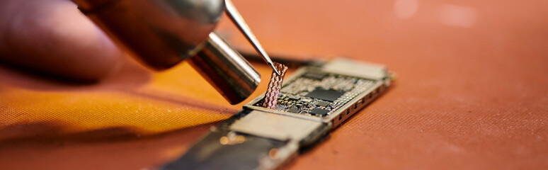 partial view of experienced technician working with microscheme of electronic gadget, banner