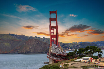The Golden Gate Bridge over the bay with mountains and lush green trees, plants and grass at the Presidio National Park in San Francisco California USA