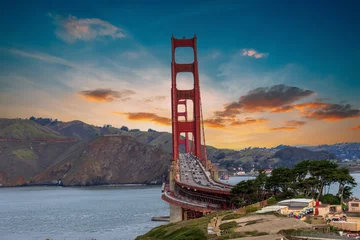 Fotobehang The Golden Gate Bridge over the bay with mountains and lush green trees, plants and grass at the Presidio National Park in San Francisco California USA © Marcus Jones