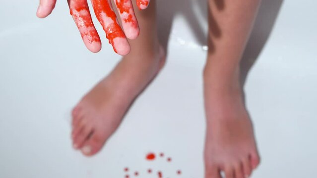 Blood from menstruation. Bloody hand of a girl in the bathroom.