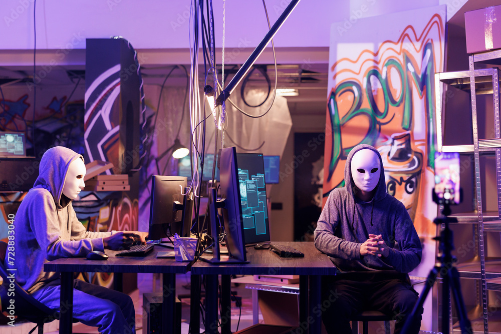 Poster internet scammers in anonymous masks threatening victim online on smartphone. hackers recording rans