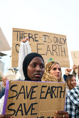 Vertical focus on African serious woman with activists people at demonstration against pollution...