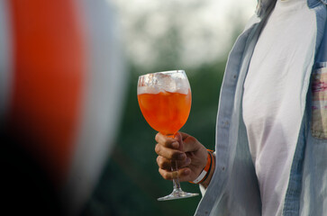 male with glass of Aperol spritz cocktails outdoors, closeup