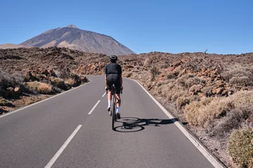 Tuinposter Canarische Eilanden Male cyclist pedaling on road with view on mountain Teide volcano,Tenerife,Canary Islands,Spain. Sportsman training hard on bicycle outdoors.Sport motivation.Cycling training outdoors.Hipster cyclist.