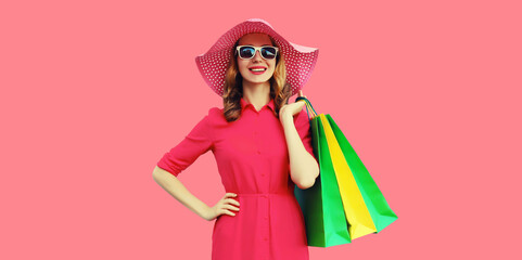 Beautiful happy smiling young woman model posing with shopping bags in summer hat