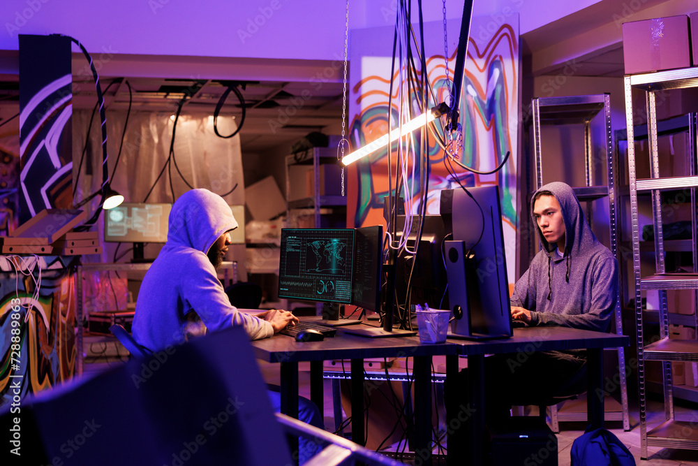 Aufkleber internet criminals working together to break into database in dark room. african american and asian 