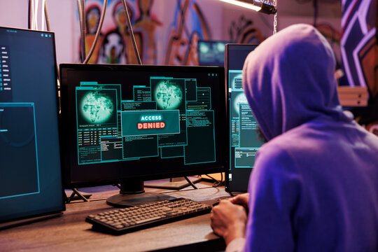 Criminal attempting to hack computer system and getting access denied. Hacker breaking into online server unsuccessfully while doing illegal activity in abandoned warehouse - Powered by Adobe