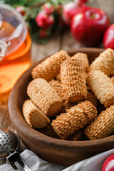 Homemade short pastry cookies in wooden bowl on rustic background with cup of tea and apples. Sweets, dessert and pastry, selective focus