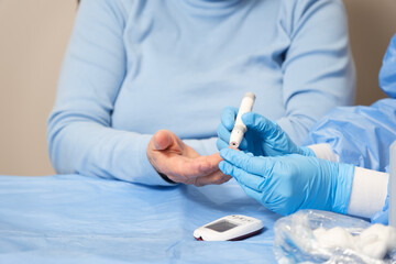 closeup on hands of nurse taking a blood test to measure blood glucose, copy space
