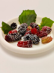 frozen mulberries in a small plate on a white background 