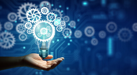 Hand holding Creative light bulb with cog inside and technology background. Innovation business...