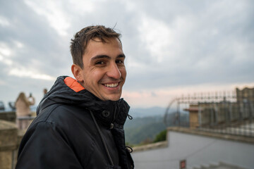 Brunet young man looking at camera in winter with a naughty face