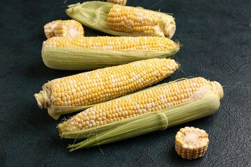Fresh corn cobs on black background